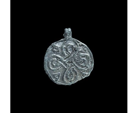 9th-12th century AD. A flat-section silver discoid plaque with integral ribbed loop, raised bilinear knot motif with pelleted