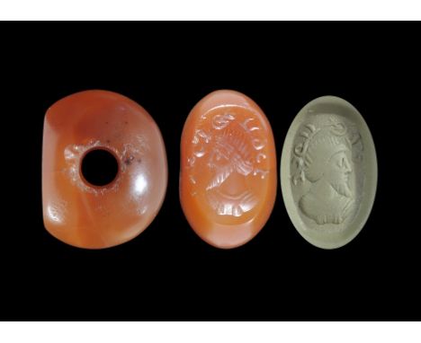 3rd-7th century AD. A carved carnelian seal matrix with intaglio bearded male bust with text above; supplied with a museum-qu