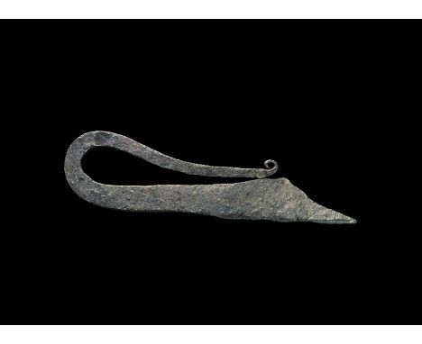 9th-12th century AD. A hand-forged square-section iron bar with scooped broad end, recurved tapered extension and scrolled fi