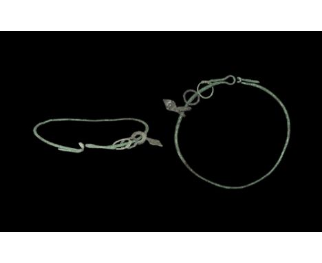 10th-12th century AD. A round-section hoop with hook and eye finials; pendant ring with coiled ends; pendant lozengiform plaq