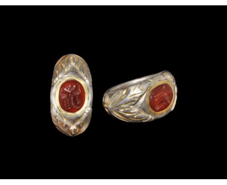3rd century AD. A parcel-gilt silver D-section hoop expanding to keeled shoulders, all with foliage detailing; the plaque wit