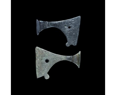 11th-12th century AD. A mixed pair of axehead pendants, each with a flared socket, scooped lower edge with spur to the rear, 