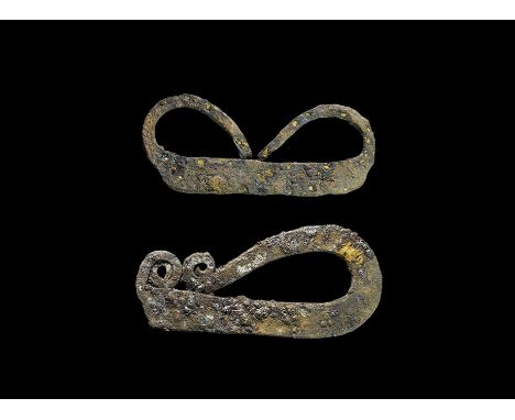9th-10th century AD. A mixed pair of iron firesteels comprising: a flat-section bar with tapered ends curved back to the midd