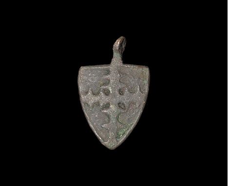 13th-15th century AD. A bronze heater shield pendant with pierced lug above, reserved border and cross engrailed motif; possi