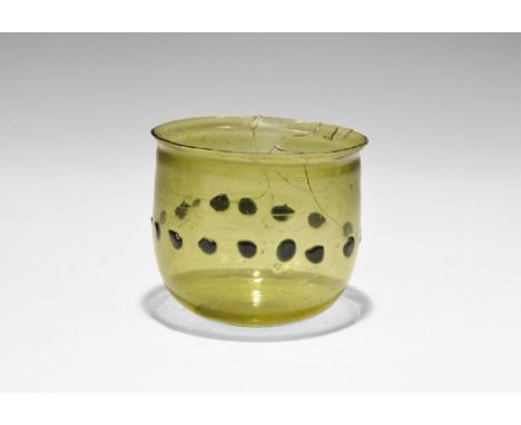 6th-7th century AD. A broad green cup with everted rim, band of applied blue-glass pellets to the equator; Gaulish workmanshi