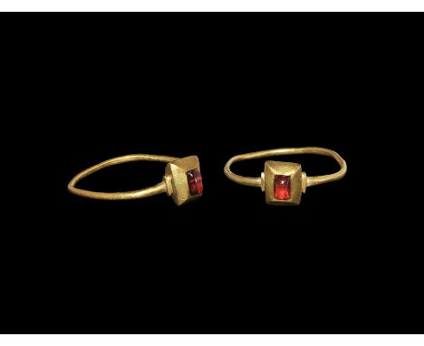 14th century AD. A narrow round-section hoop with stepped shoulders, pie-dish bezel and inset garnet cabochon. 1.44 grams, 22