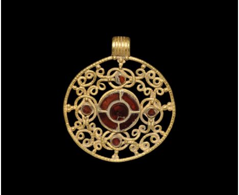 6th-7th century AD. A gold openwork pendant plaque with ribbed loop, notched outer ring with granule detailing, filigree coil