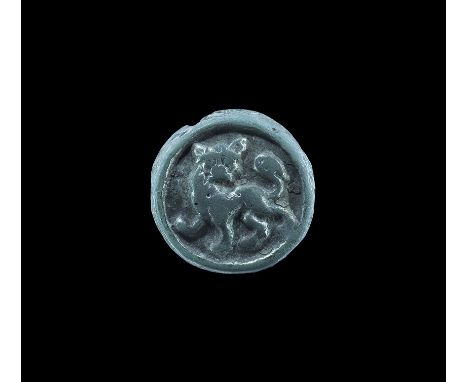 10th-12th century AD. A discoid bronze mount with chamfered rim, high-relief image of an advancing lion facing with tail rais