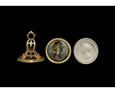 19th century AD. A gold mounted fob seal with openwork frame and circular bloodstone face depicting an intaglio profile bust 