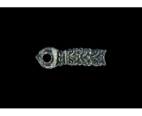 10th-12th century AD. A rectangular silver-gilt mount with pierced lobe terminal; the face with tight foliage in high relief,