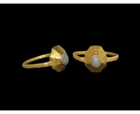 13th-15th century AD. A square-section gold hoop supporting an octagonal plaque and facetted cone with inset glass cabochon. 