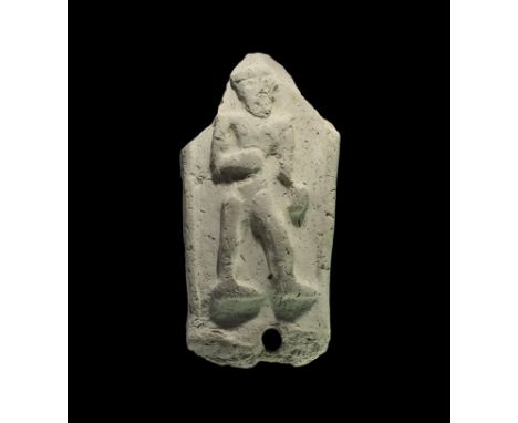 2000-1600 BC. A ceramic D-section plaque with hole to the lower edge, high-relief advancing figure within borders; accompanie