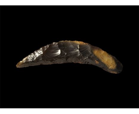 Neolithic, 4th-2nd millennium BC. A curving flint sickle with serrated edge and narrowing to a point at one end. 50 grams, 15