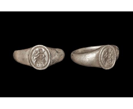 2nd century AD. A D-section silver hoop with keeled shoulders, discoid plaque with beaded border, intaglio figure of Minerva 