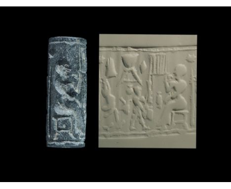 1400-1000 BC. A bitumen cylinder seal with raised borders to the upper and lower edges, scene of preparation of meat and drin