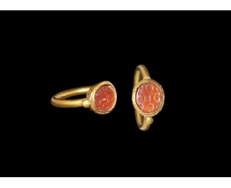 3rd-7th century AD. A round-section gold hoop supporting a discoid cell with chamfered rim, pellets to the shoulders, inset c