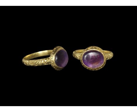 16th-17th century AD. A gold ring with shank decorated with floral scroll work; bezel is set with an amethyst cabochon pierce