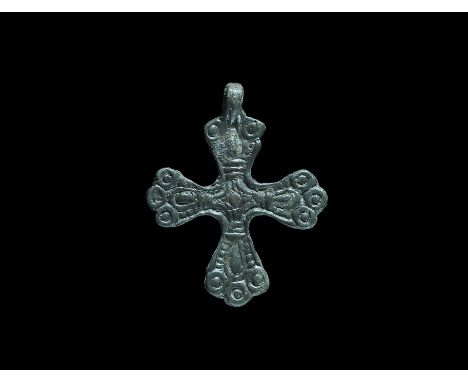 10th-12th century AD. A flat-section bronze cross with integral loop, internal cross decoration with large central dot, three