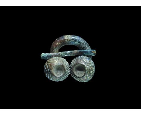 13th century AD. A bronze round-section penannular shank with two domed finials, each with incised arches; small round-sectio