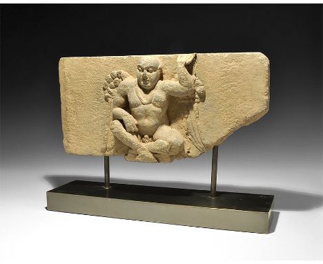 2nd-3rd century AD. A schist panel fragment with Atlas shown with legs crossed and nude except for a necklace; right arm rest