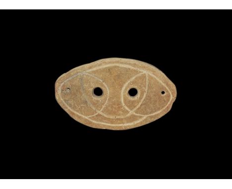 4th-3rd century BC. An elliptical slightly curved ceramic mask with two eye-holes and incised stylised facial details; pierce