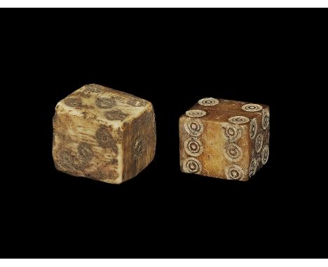 1st century BC-3rd century AD. A pair of carved bone cuboid dice with ring-and-dot markings, one configured 1:6, 2:5, 3:4 and