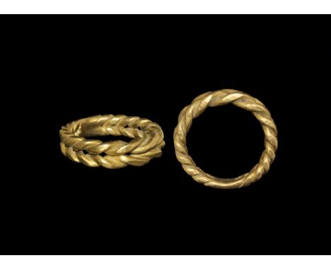 9th-11th century AD. A substantial gold ring formed as two twisted hoops placed side-by-side in a herringbone pattern; connec