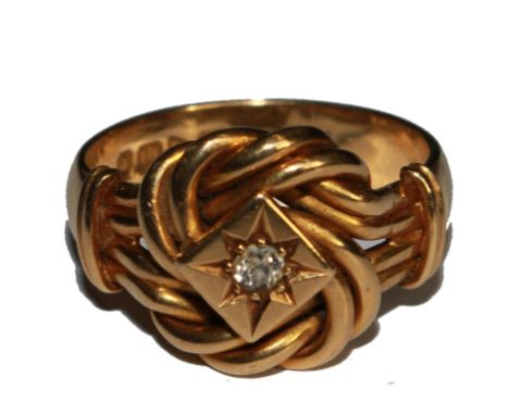An 18 carat gold knot ring with central diamond