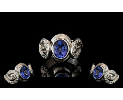 18ct White Gold Sapphire &amp; Diamond Designer Ring, set with a central oval cut Sapphire between two diamond set applied sc