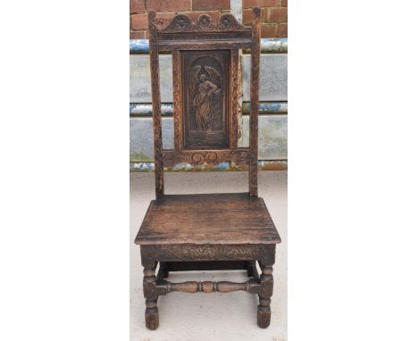 An early to mid 19th century Wainscot-style oak chair with carved back panel, 108cm tall.  In good functional condition, fair