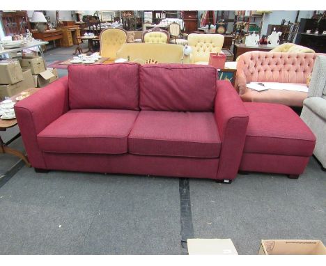 A modern red large two seater sofa and matching pouffe       