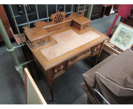 An Arts &amp; Crafts late Victorian walnut writing table in the manner of "William Birch", the fretwork raised back and two s