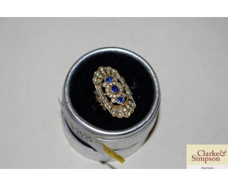 A yellow metal ring set blue and white stones, 11gms