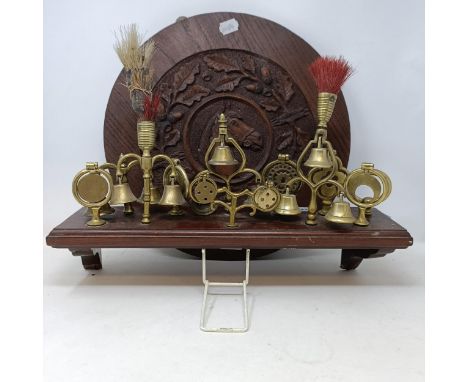 A carved oak roundel, decorated horse, surrounded by oak leaves, 42 cm diameter, and a mahogany shelf, mounted with heavy hor