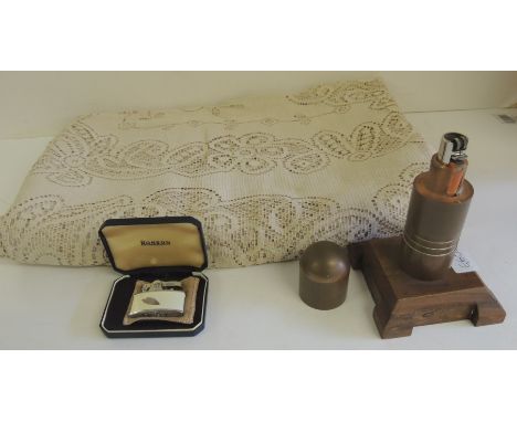 A large machine made lacework table cover; a small Ronson cigarette lighter in original box and a heavy copper cylinder on wo