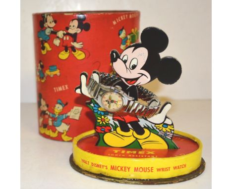 A TIMEX MICKEY MOUSE WRISTWATCH AND STAND the watch with Mickey Mouse on the dial having moving hands and expanding white met