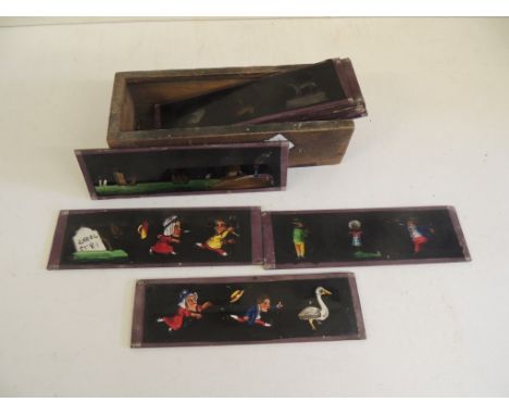 A group of 12 hand painted nursery magic lantern slides painted with assorted figures and animals in wooden box