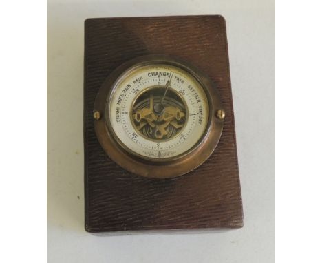 An early 20th Century desk barometer/paperweight, in rectangular leather covered case, 10.5cms x 7.25cms x 4cms high