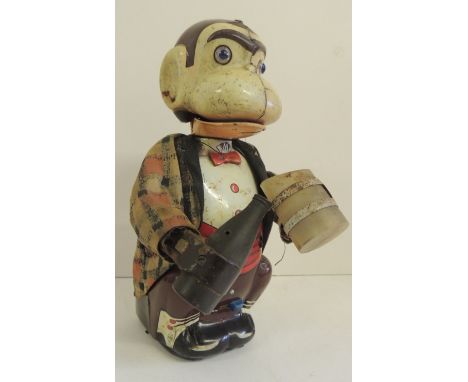 LINEMAR, JAPAN - a battery operated tinplate toy monkey holding bottle and mug and with glass eyes, when operated the monkey'