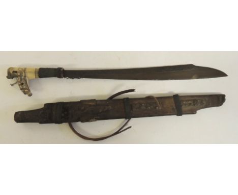 A late 19th Century Dyak Mandau with carved horn hilt, woven hair grip, blade of typical form with decorative top edge to one