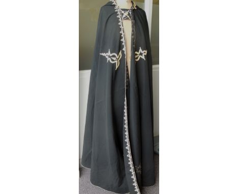 A black cloak with hood, trimmed with gold cord