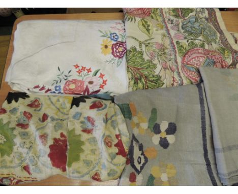 A large white damask table cover with central panel worked in coloured silks with flowers; two large Batik print covers and o