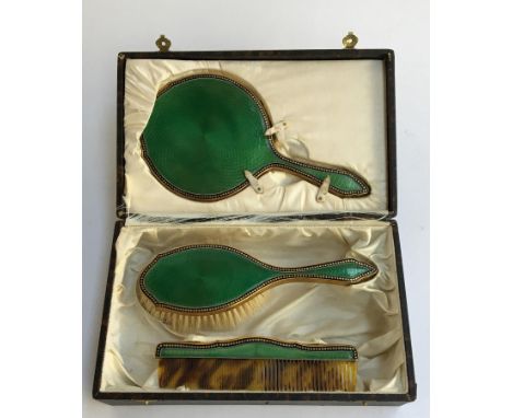 A guilloche enamel gilt dressing table set, comprising comb, brush and vanity mirror 