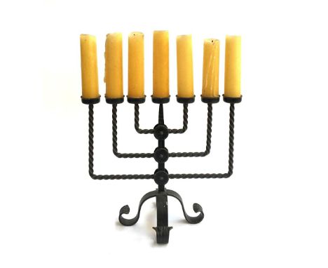 A wrought iron seven arm candlestick, with candles, 44cmW 