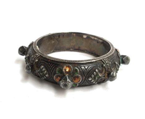 Persian heavy white metal slave bangle with some faded enamel decoration together with a small oval mat, possibly Persian emb