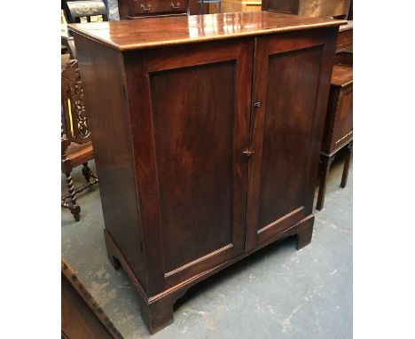 A George III gents hanging wardrobe, enclosed by two panelled doors, on bracket feet, 111x61x133cmH 
