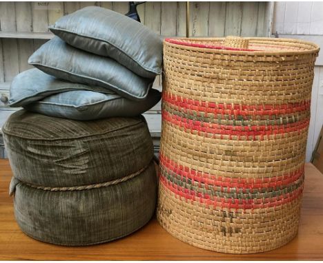 A wicker laundry basket, 58cmH, containing various cushions, together with a small circular pouffe 