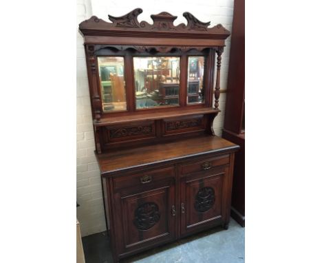 An early 20th century mahogany chiffonier, the top with acanthus carved broken pediment, above three bevelled glass mirrors a