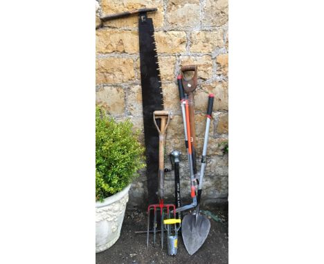 A mixed lot of tools comprising garden forks, shovel, clippers, two handled bow saw, etc 