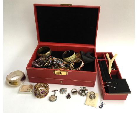 Red jewellery box containing costume jewellery to include a rolled gold bangle, further bangles, bracelets and other items 